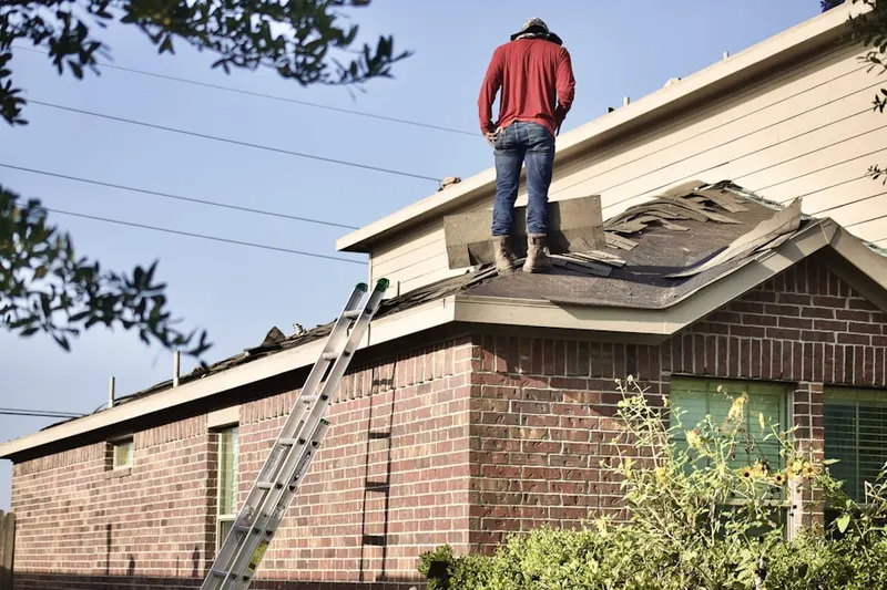 Professional roofer working on a residential roof in Bigelow Corners
